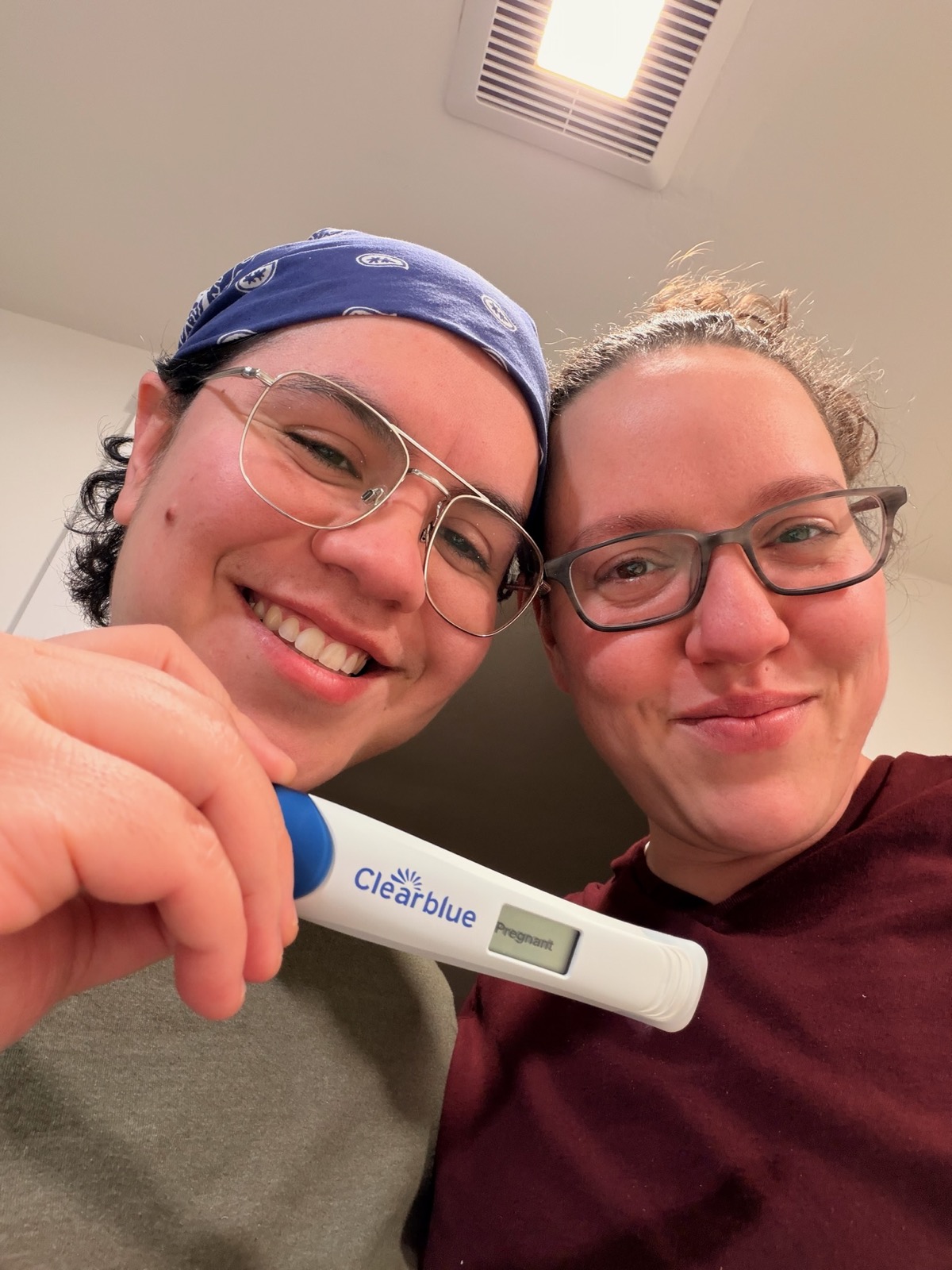 Megan and Sofia smiling with a positive pregnancy test